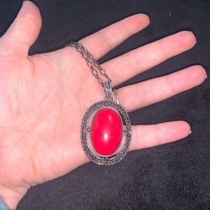 Long chained necklace with a red marble stone pendant.
